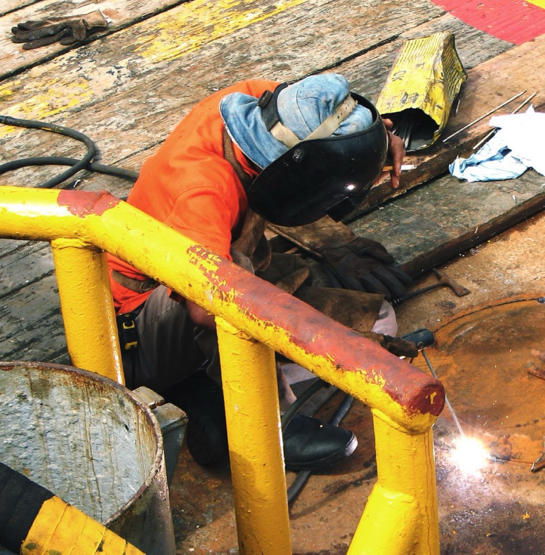Welder repairing a steel safety railing