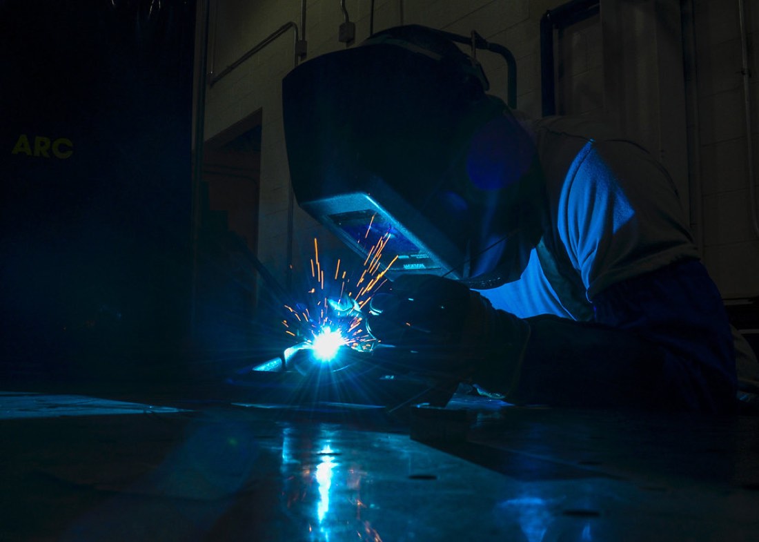 TIG arc glowing under a welding helmet